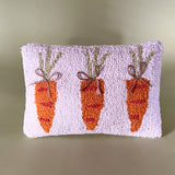 A white easter pillow with three orange carrots