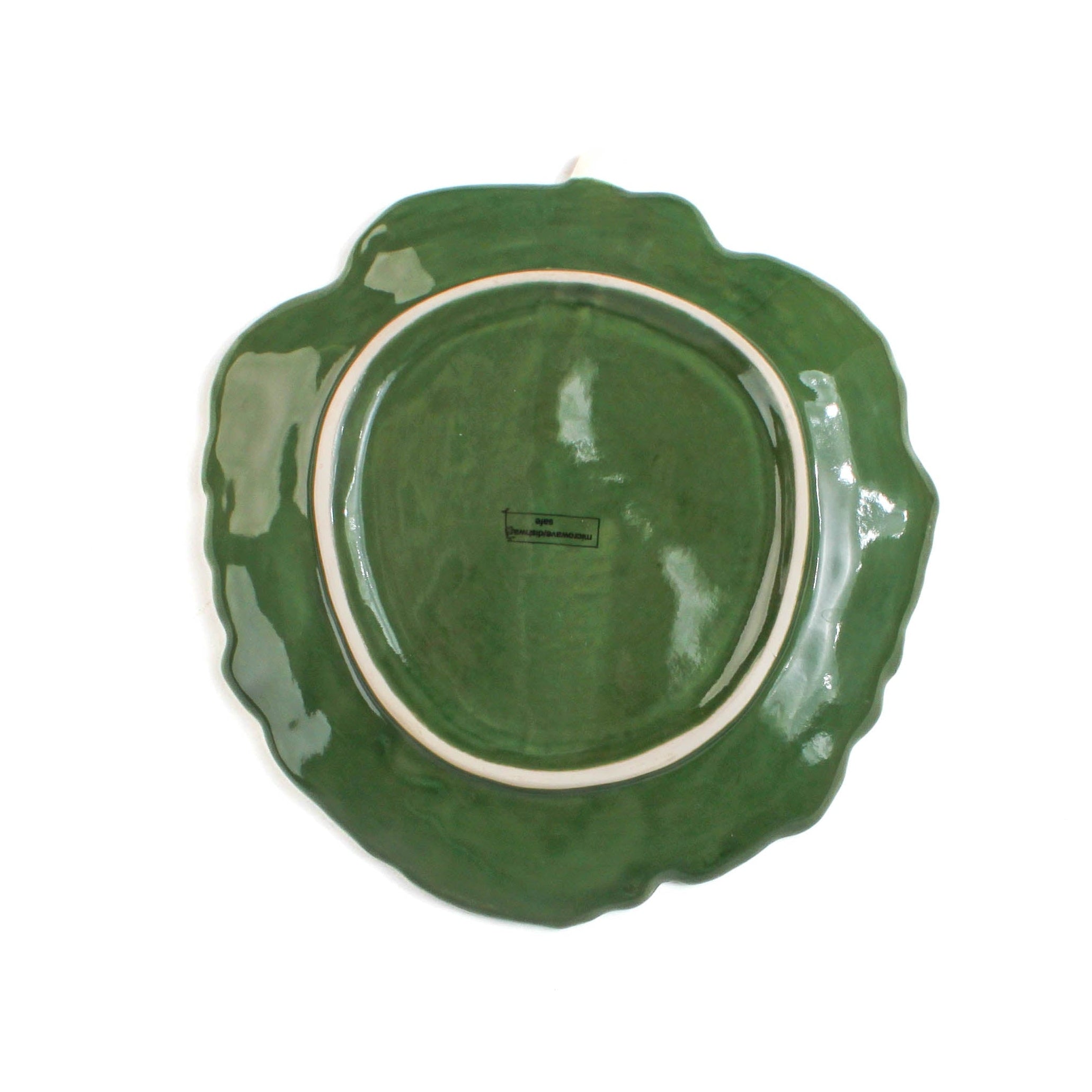 a ceramic cabbage leaf bowl bottom view in a white background