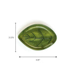 Green ceramic leaf-shaped dish with painted vein details, shown on a white background with dimensions 5⅝ inches wide and 3.375 inches tall.