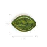Green ceramic leaf-shaped dish with painted vein details, shown on a white background with dimensions 5⅝ inches wide and 3.375 inches tall.