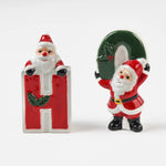 Two ceramic christmas salt and pepper shakers shaped like the letters 'H' and 'O' with Santa Claus figures on a white background.