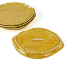 four textured yellow lemon shaped plates with 1 showing the back on a white background