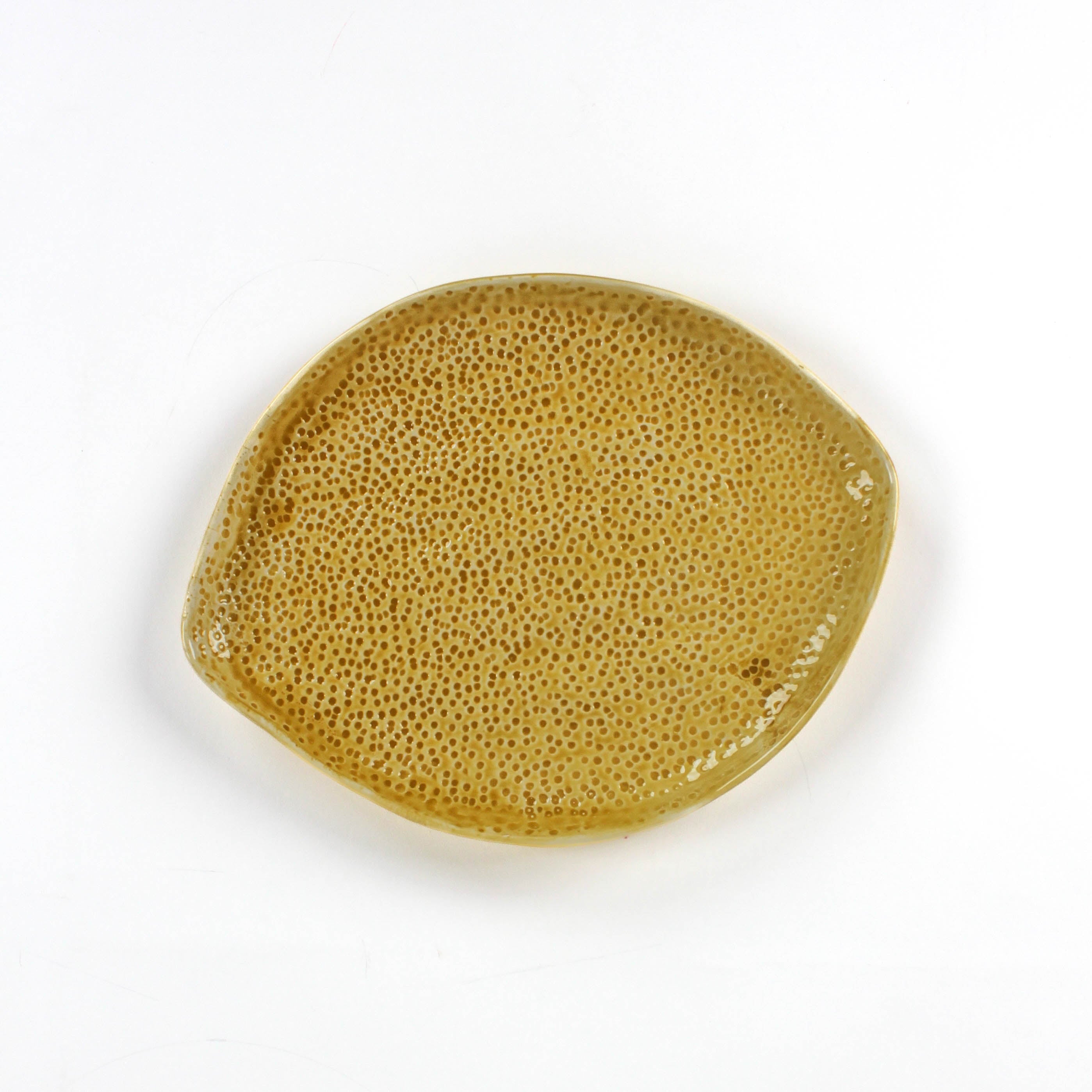 front of a textured yellow lemon shaped plate on a white background
