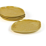 four textured yellow lemon shaped plates on a white background