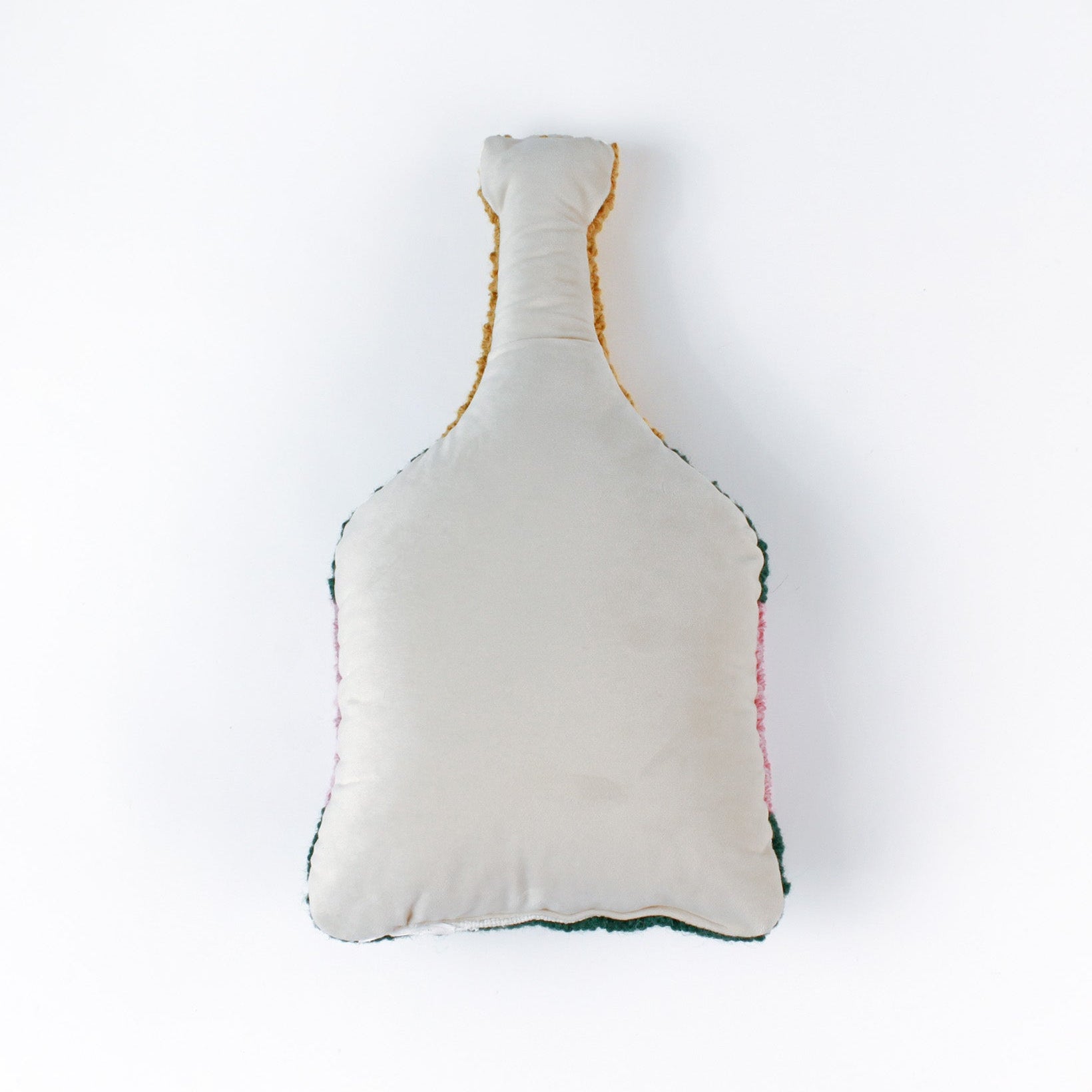 back of a bottle-shaped decorative pillow with a hooked texture, designed like a champagne bottle in green, pink, and gold colors, featuring the word “Cheers” on the label.