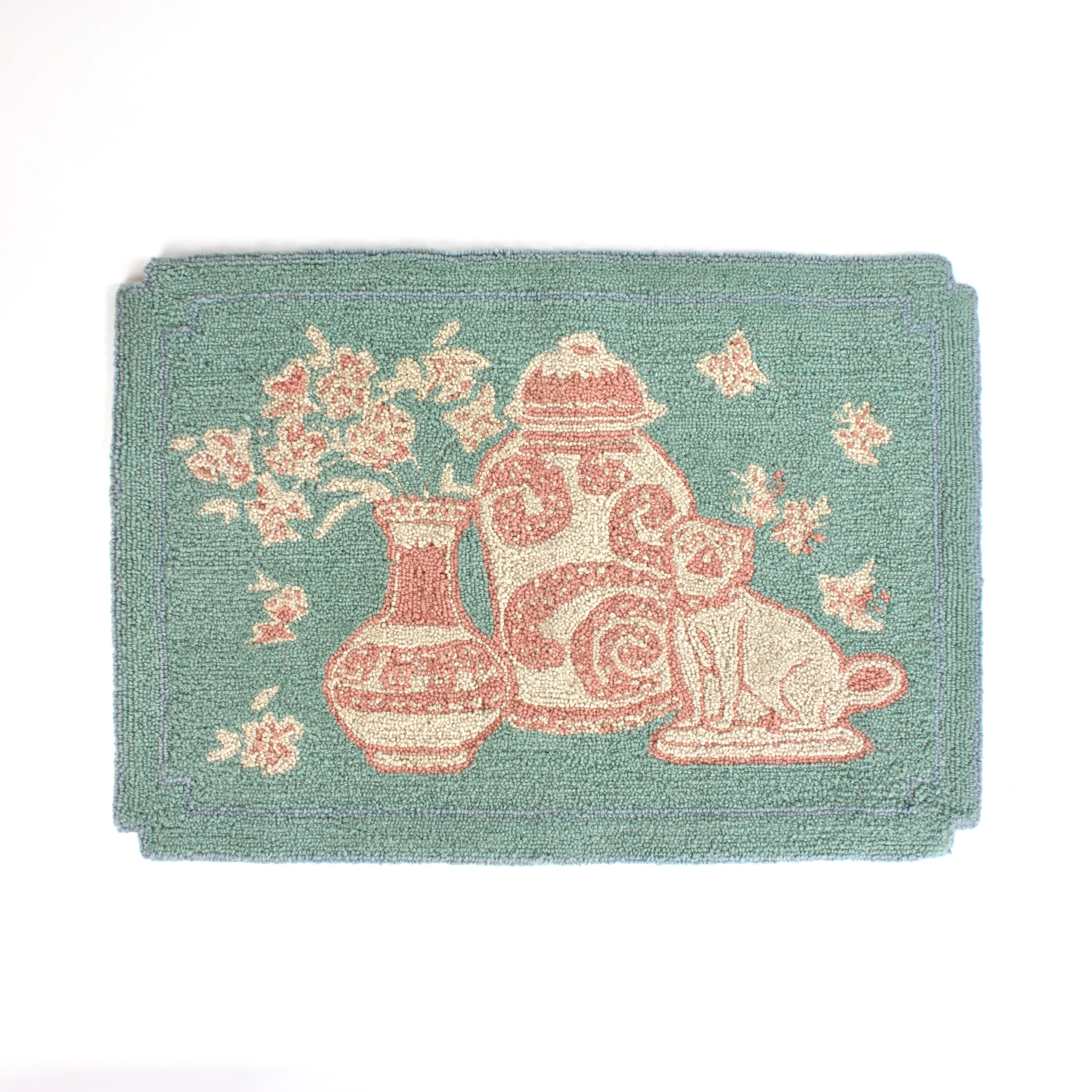 A small pink and green rug with chinoiserie motifs.
