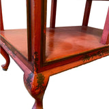 a dark wood chinoiserie side table with two tiers and on rolling casters.