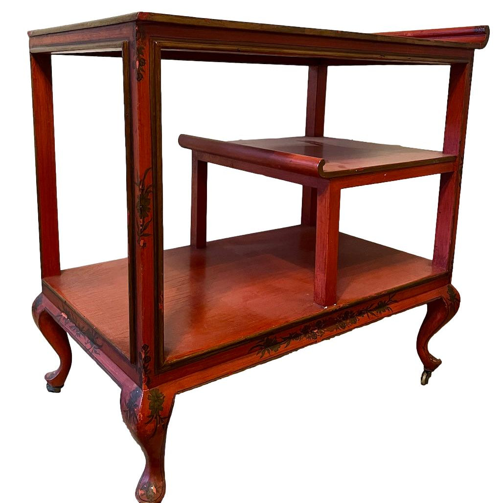 a dark wood chinoiserie side table with two tiers and on rolling casters.