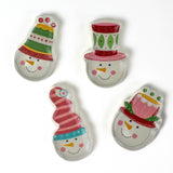 Four colorful snowman ceramic christmas plates on a white background