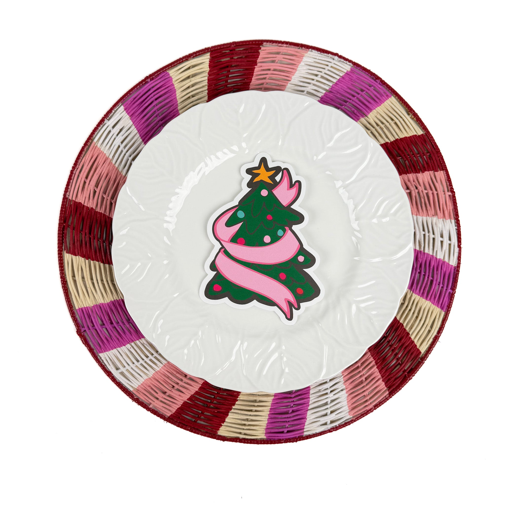 a christmas tree place card on top of a plate and rattan placemat