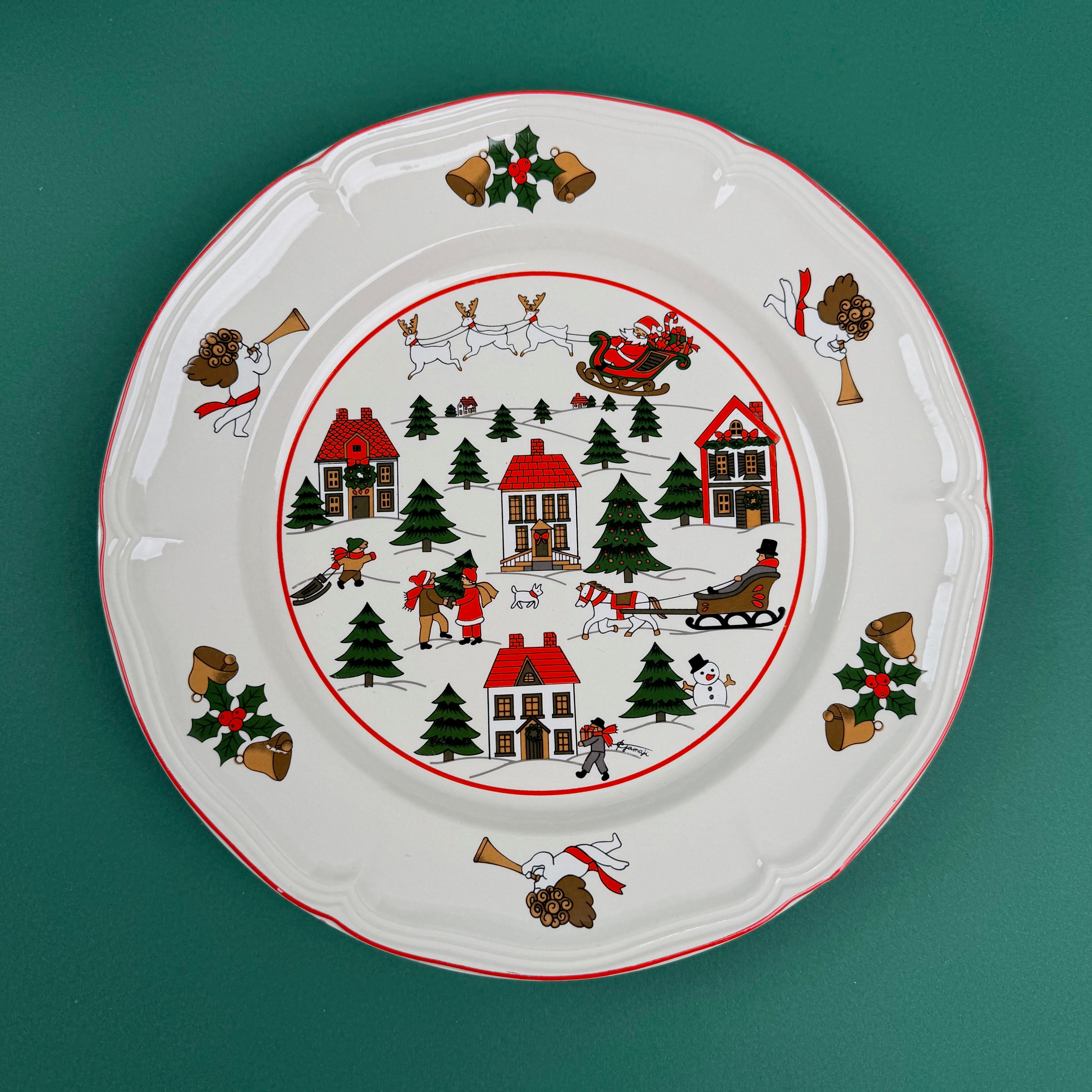 Christmas village-themed dinner plate with Santa, houses, trees, and holiday illustrations on a green background