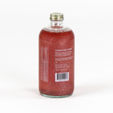 a bottle of candy cane peppermint mix. the contents are red and glittery and the largest text reads "Candy Cane Cosmo" 