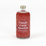 a bottle of candy cane peppermint mix. the contents are red and glittery and the label reads "Candy Cane Sparkle" 