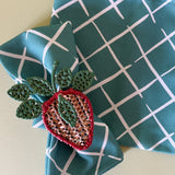 bahama court green dinner napkin closeup with rattan strawberry napkin ring