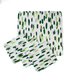 Set of four green brush stroke patterned dinner napkins on a white background, neatly stacked with stitched edges, designed for modern table settings and coordinated with a Christmas tea towel.