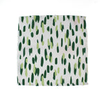Green brush stroke patterned dinner napkin on a white background 