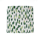 Green brush stroke patterned dinner napkin on a white background 