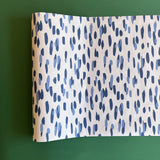 A blue and white paper table runner featuring a brushtroke pattern called Club House by Madcap Cottage