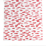 A pink and white paper table runner with a brushtroke pattern on a white background