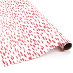 Roll of pink brushstroke wrapping paper on a white background.