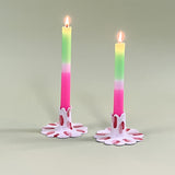 Pair of madcap cottage ceramic candle holders with scalloped edges and a red and Club House pattern holding taper candles.
