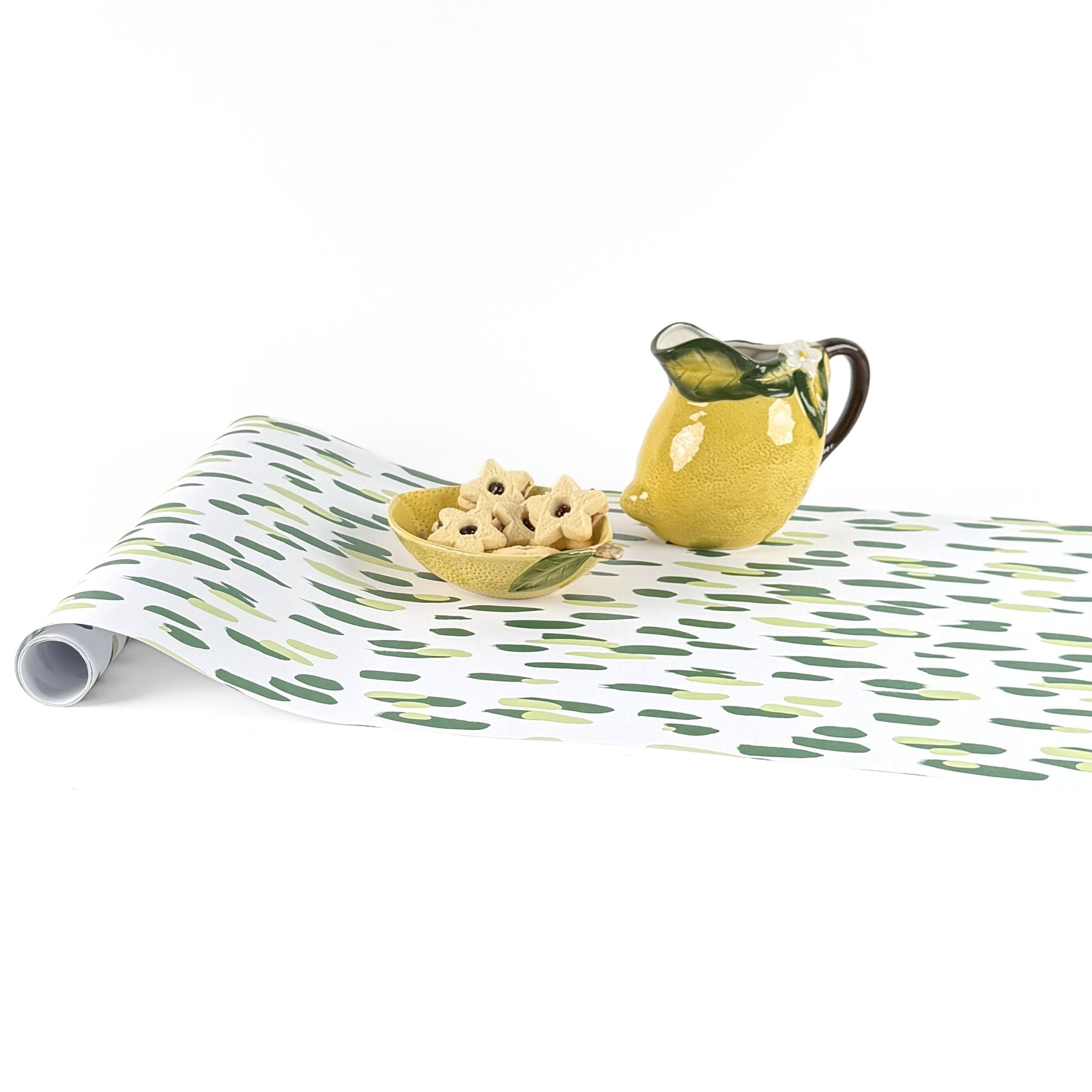 Clubhouse green paper table runner styled with lemon pitcher and decorative bowl.