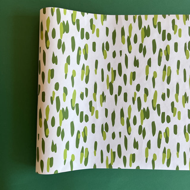 A green and white paper table runner with a brushtroke pattern