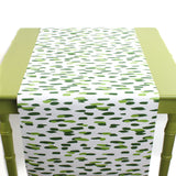 a green table covered with a green and white paper table runner with a brushtroke pattern