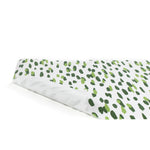 A green and white paper table runner with a brushtroke pattern on a white background