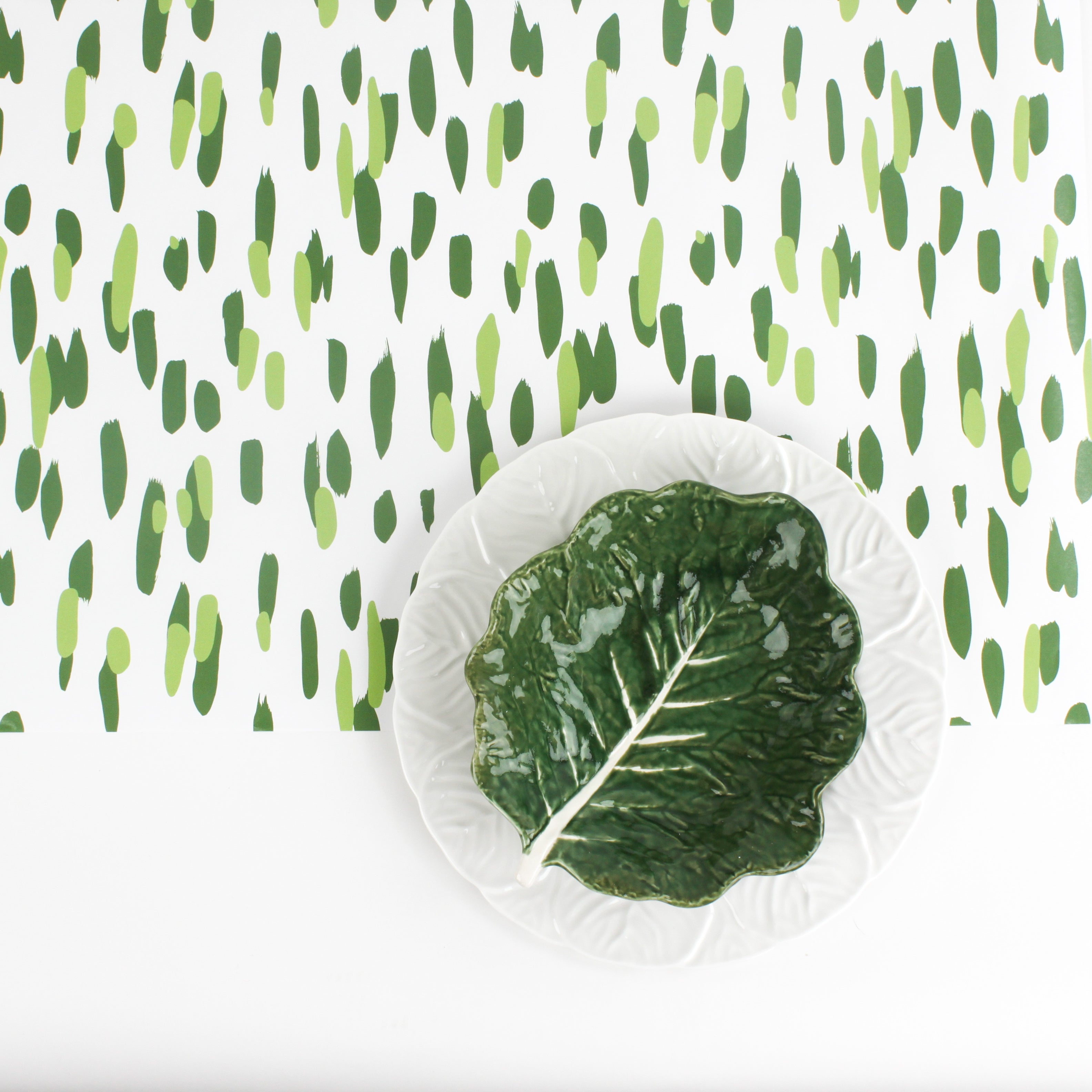 A cabbage plate on a green and white paper table runner with a brushtroke pattern