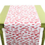 a green table covered with A pink and white paper table runner with a brushtroke pattern on a white background
