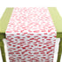a green table covered with A pink and white paper table runner with a brushtroke pattern on a white background