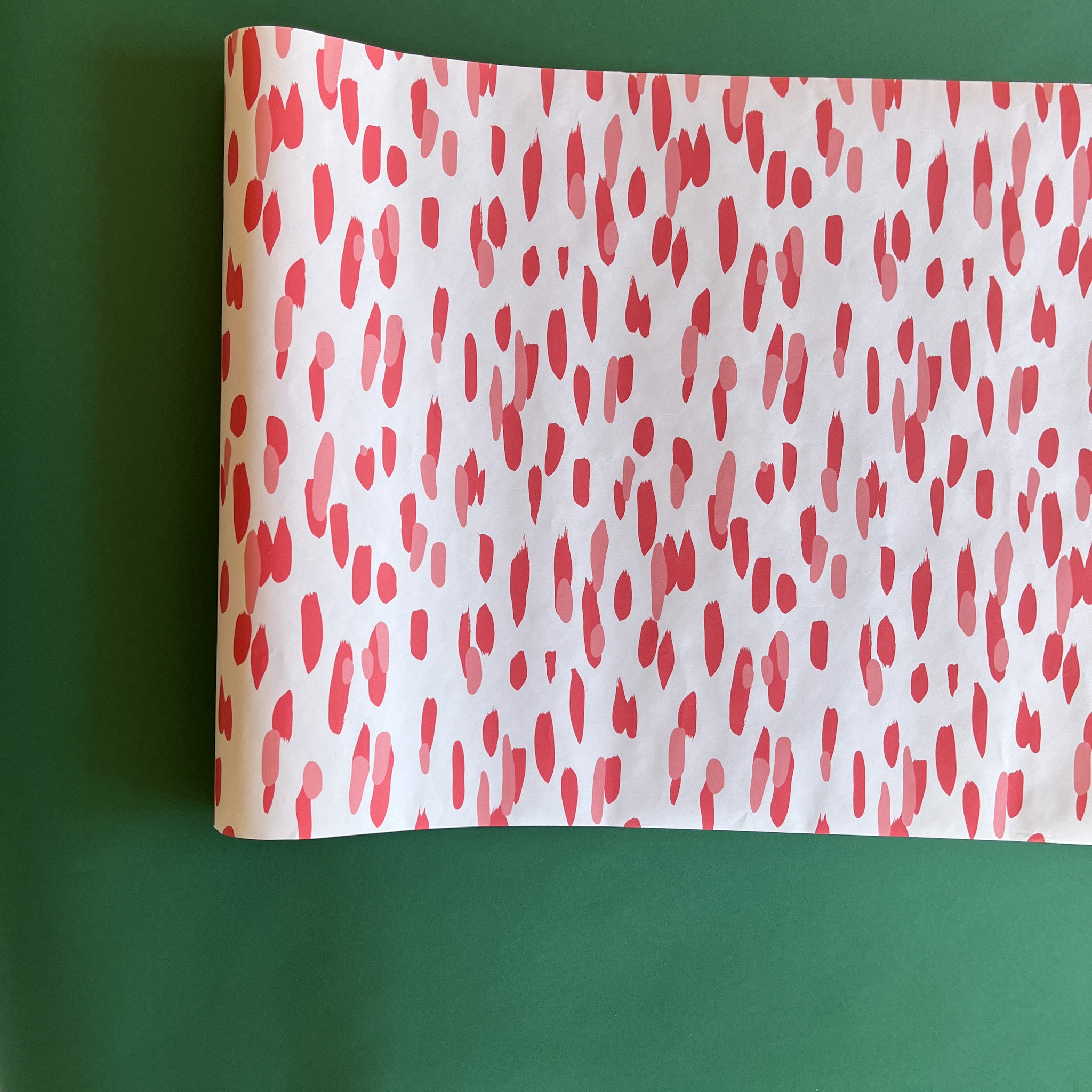 A white and red paper table runner featuring a brushtroke pattern called Club House by Madcap Cottage
