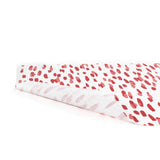 A white and red paper table runner featuring a brushtroke pattern called Club House by Madcap Cottage