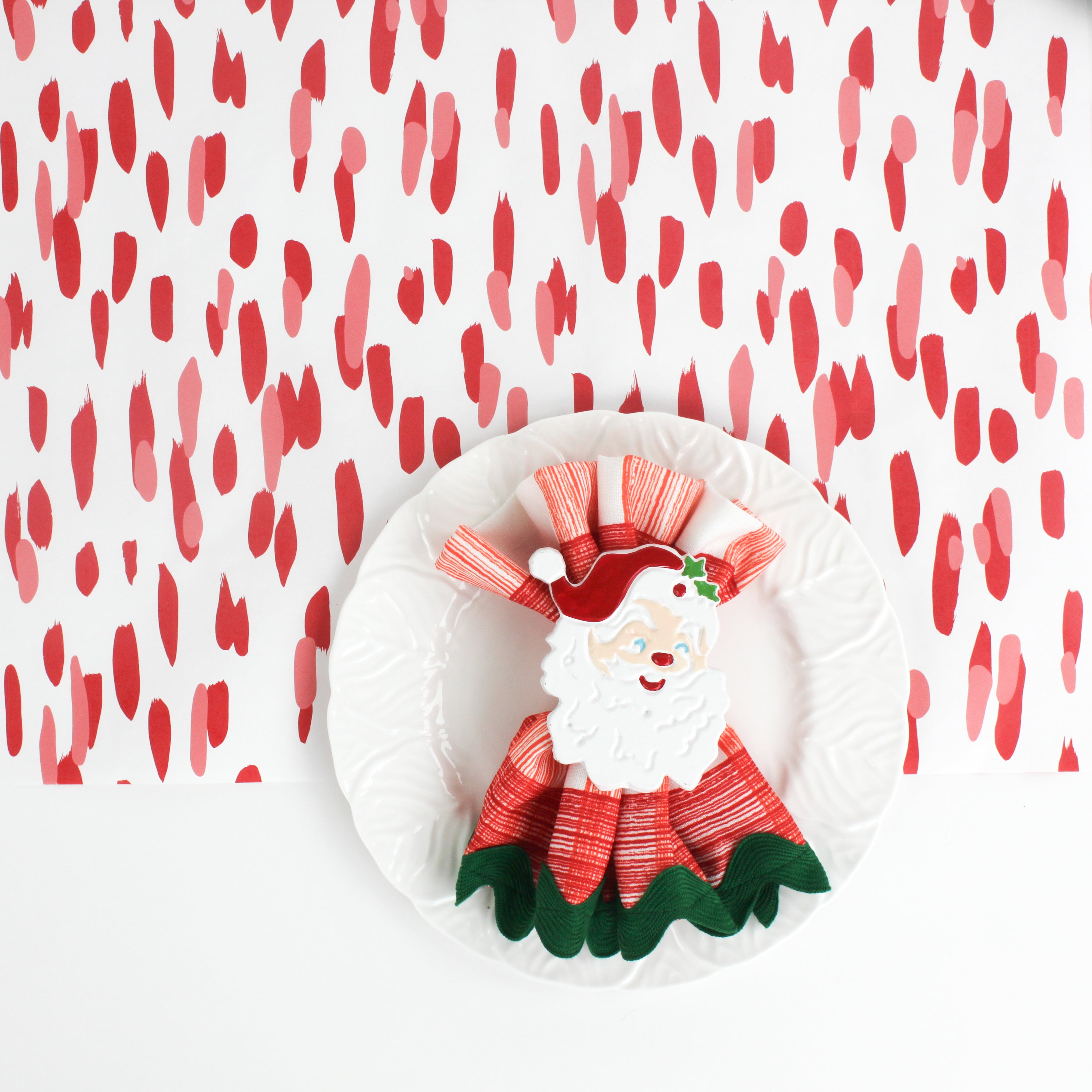 A white and red paper table runner featuring a brushtroke pattern called Club House by Madcap Cottage