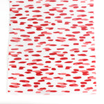 A white and red paper table runner featuring a brushtroke pattern called Club House by Madcap Cottage