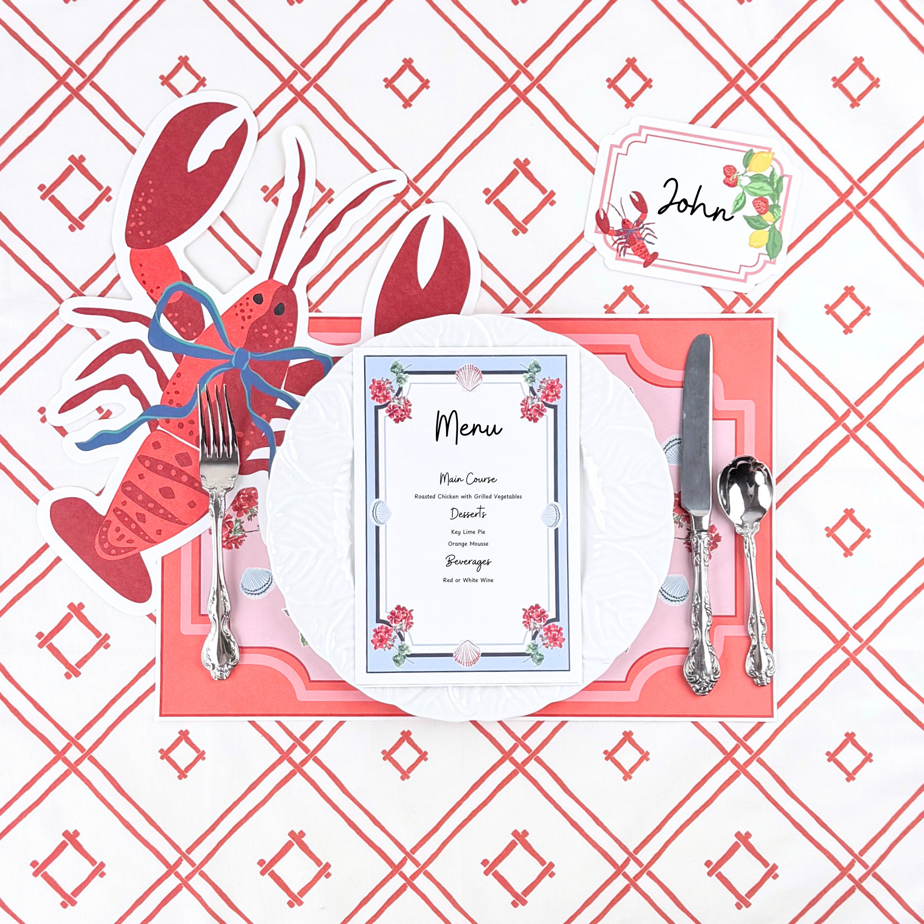 a menu card with geranium and shell design placed on a lobster-themed placemat, and cutlery on a red and white checkered background.