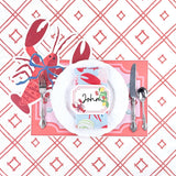 Coastal themed table setting featuring a lobster place card, lobster shaped placemat, white dinner plate, and coral trellis patterned background.