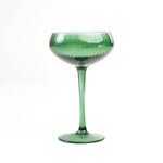 a green coupe glass from madcap cottage in a white background