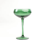 a green coupe glass from madcap cottage in a white background