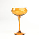 a yellow coupe glass from madcap cottage in a white background
