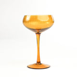 a yellow coupe glass from madcap cottage in a white background