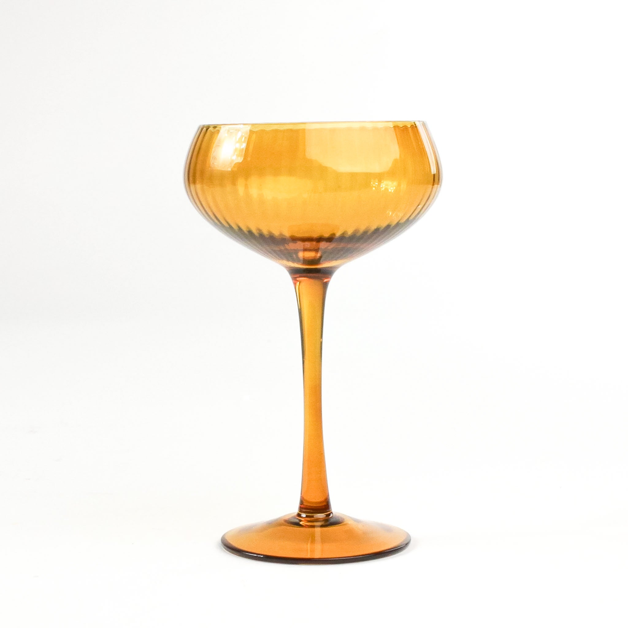 a yellow coupe glass from madcap cottage in a white background