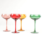 Set of Four Colored Champagne Glasses in yellow, green, pink and red in a white background