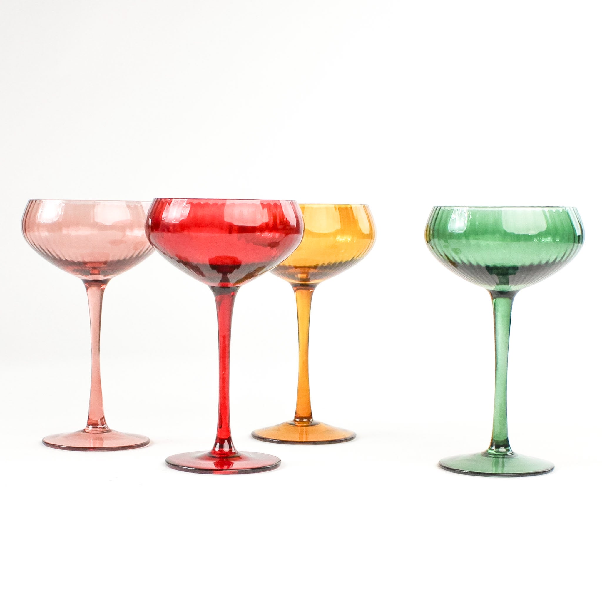 Set of Four Colored Champagne Glasses in yellow, green, pink and red in a white background