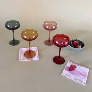 colored champagne glasses with cocktail napkins