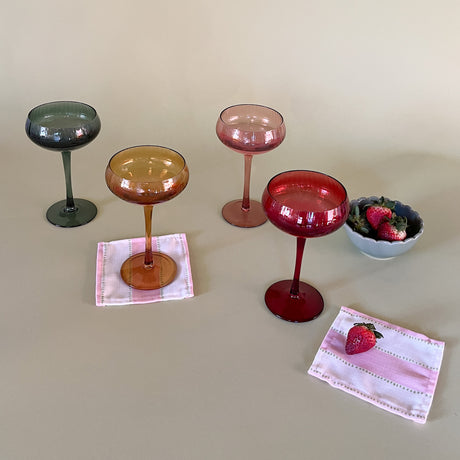colored champagne glasses with cocktail napkins