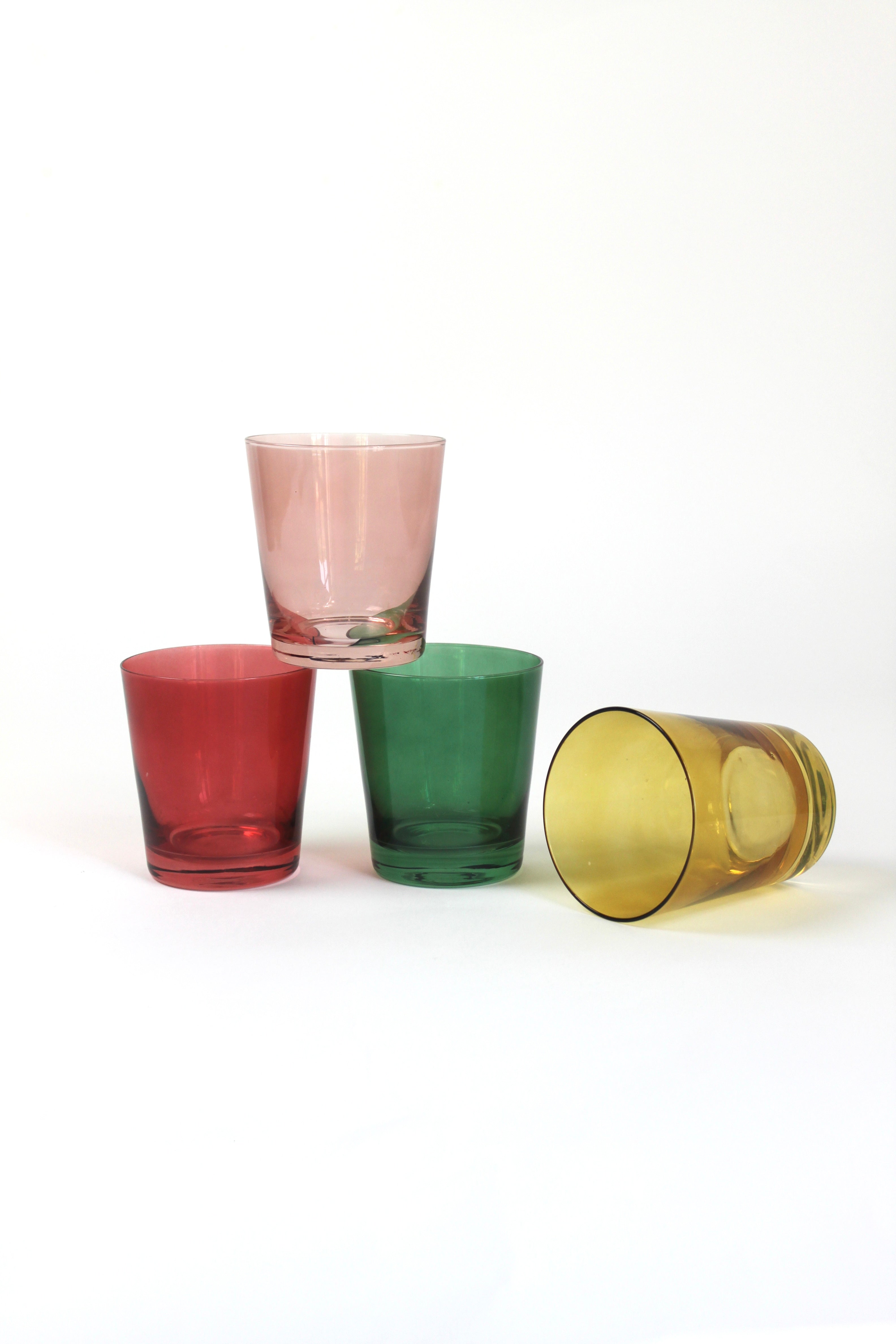 Four colored drinking glasses in pink, red, green and yellow from madcap cottage