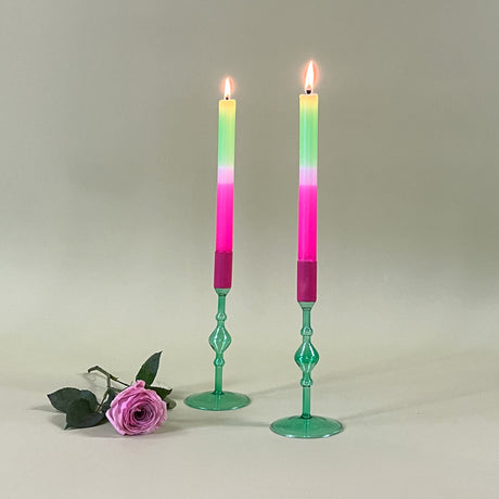 two green colored glass candle holders with pink tops and pastel taper candles