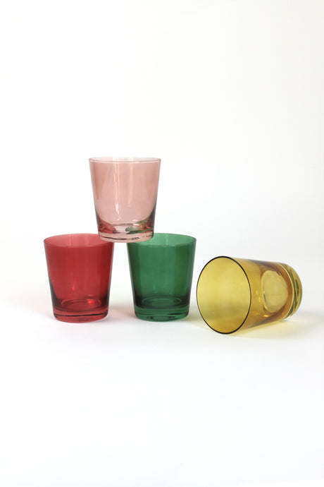 Four colored drinking glasses in pink, red, green and yellow from madcap cottage